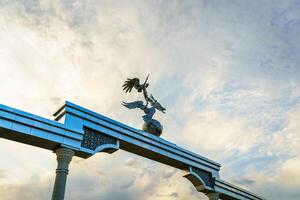 TASHKENT, UZBEKISTAN - MAY 25, 2023 Independence Memorial at Independence Square in Tashkent at sunset with cloudy sky. photo