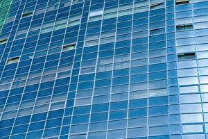 fragmento de un moderno oficina edificio. resumen geométrico antecedentes. parte de el fachada de un rascacielos con vaso ventanas foto