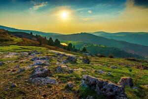 Foggy sunset or dawn in the mountains covered with grass and cloudy dramatic sky. photo