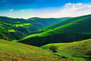 colinas y montañas cubierto con joven verde césped y iluminado por el Dom en un soleado día. foto