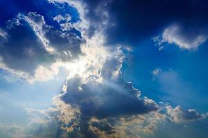 Sunbeams breaking through dramatic cumulus clouds. Change of weather. Hope or religion concept. photo