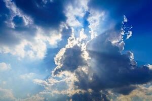 Sunbeams breaking through dramatic cumulus clouds. Change of weather. Hope or religion concept. photo