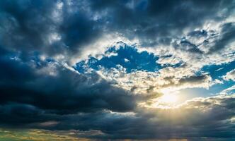 The sun breaking through storm clouds in a flowering rapeseed field. photo