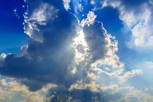 Sunbeams breaking through dramatic cumulus clouds. Change of weather. Hope or religion concept. photo