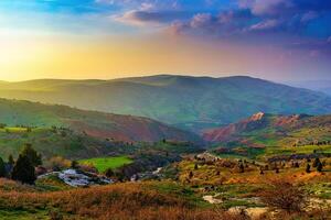 Foggy sunset or dawn in the mountains covered with grass and cloudy dramatic sky. photo