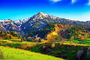 Mountain top covered with young snow and illuminated by the sun on a sunny day. Mountain landscape. photo