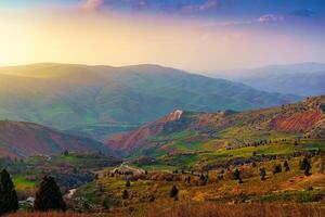 Foggy sunset or dawn in the mountains covered with grass and cloudy dramatic sky. photo