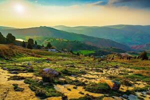 Foggy sunset or dawn in the mountains covered with grass and cloudy dramatic sky. photo