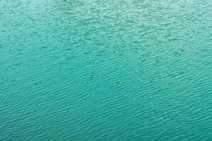 The texture of the waves of turquoise color of fast-flowing water in the river. photo