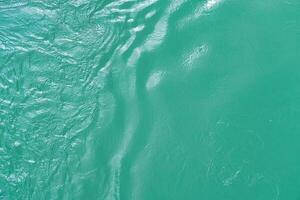 The texture of the waves of turquoise color of fast-flowing water in the river. photo