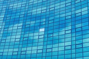 Fragment of a modern office building. Abstract geometric background. Part of the facade of a skyscraper with glass windows. photo