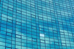 Fragment of a modern office building. Abstract geometric background. Part of the facade of a skyscraper with glass windows. photo