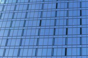 Fragment of a modern office building. Abstract geometric background. Part of the facade of a skyscraper with glass windows. photo