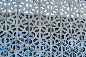 The texture of the cladding of a building made of metal aluminum panels with a carved pattern. Abstract background. photo