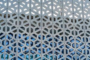 The texture of the cladding of a building made of metal aluminum panels with a carved pattern. Abstract background. photo