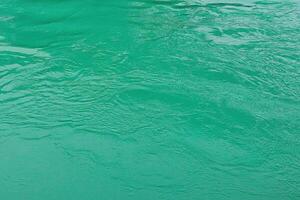 The texture of the waves of turquoise color of fast-flowing water in the river. photo