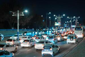 borroso coche tráfico ligero a noche ciudad. tráfico mermelada en noche prisa hora. foto