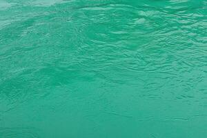 The texture of the waves of turquoise color of fast-flowing water in the river. photo