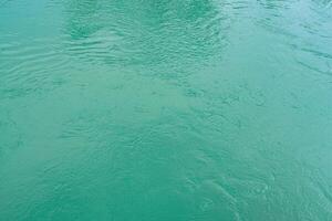 The texture of the waves of turquoise color of fast-flowing water in the river. photo