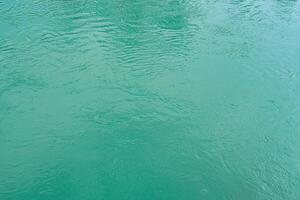 The texture of the waves of turquoise color of fast-flowing water in the river. photo