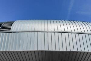 A modern building covered with metal aluminum panels against the blue sky. photo