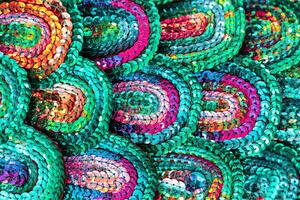 Beautiful multi-colored sequins shimmering in the light in the form of a peacock tail. Abstract background. photo