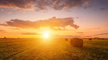 A field with haystacks on a summer or early autumn evening with a cloudy sky in the background. photo