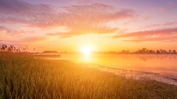 Scenic view of beautiful sunrise or dawn above the pond or lake at spring or early summer morning. photo