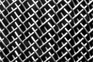 Monochrome texture of a shiny metal colander or grate. Abstract background. photo