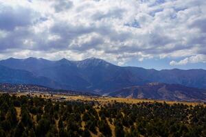 Mountains covered with grass and trees and cloudy dramatic sky on a daytime in Zaamin reserve. photo