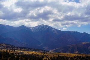 Mountains covered with grass and trees and cloudy dramatic sky on a daytime in Zaamin reserve. photo