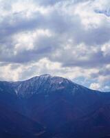 Mountain top covered with young snow and illuminated by the sun on a sunny day in Zaamin reserve. photo