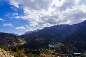 Mountains covered with grass and trees and cloudy dramatic sky on a daytime in Zaamin reserve. photo