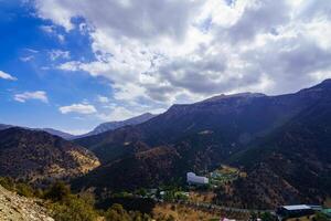 Mountains covered with grass and trees and cloudy dramatic sky on a daytime in Zaamin reserve. photo