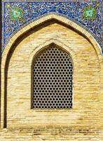 The window of a Muslim mosque behind bars in the form of a geometric round Islamic ornament. photo