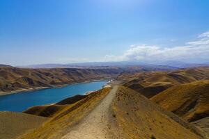 A deserted part of the Zaamin nature reserve in Uzbukistan on a sunny summer day. View of the mountains and reservoir. photo