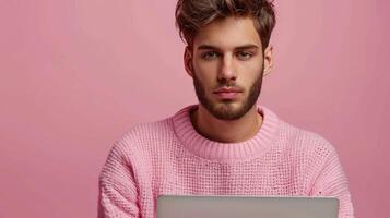 A man wearing a pink sweater holding a laptop photo