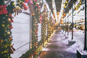 Navidad o nuevo años mercado en un Europa con casas decorado con juguete pelotas y guirnaldas a noche. Clásico película estético. foto