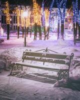 invierno parque a noche con Navidad decoraciones, brillante linternas, pavimento cubierto con nieve y arboles Clásico película estético. foto