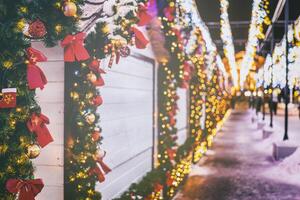Navidad o nuevo años mercado en un Europa con casas decorado con juguete pelotas y guirnaldas a noche. Clásico película estético. foto