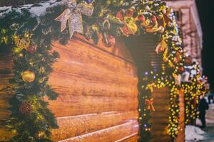 Navidad o nuevo años mercado en un Europa con casas decorado con juguete pelotas y guirnaldas a noche. Clásico película estético. foto