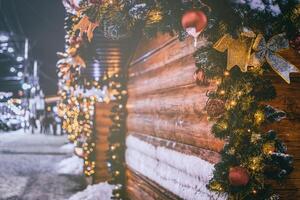Navidad o nuevo años mercado en un Europa con casas decorado con juguete pelotas y guirnaldas a noche. Clásico película estético. foto