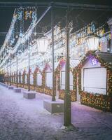 Christmas or New Year's market in a Europe with houses decorated with toy balls and garlands at night. Vintage film aesthetic. photo