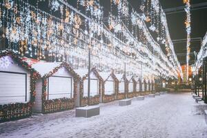 Navidad o nuevo años mercado en un Europa con casas decorado con juguete pelotas y guirnaldas a noche. Clásico película estético. foto