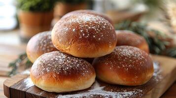 A stack of bread rolls placed on a wooden cutting board photo