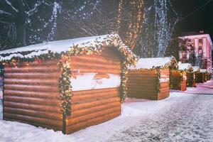 Navidad o nuevo años mercado en un Europa con casas decorado con juguete pelotas y guirnaldas a noche. Clásico película estético. foto