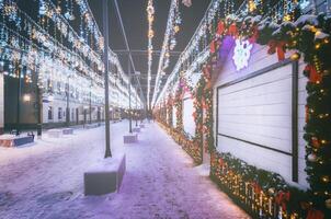 Navidad o nuevo años mercado en un Europa con casas decorado con juguete pelotas y guirnaldas a noche. Clásico película estético. foto