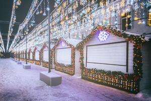 Navidad o nuevo años mercado en un Europa con casas decorado con juguete pelotas y guirnaldas a noche. Clásico película estético. foto