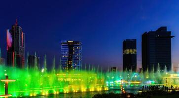 uzbekistán, Tashkent - septiembre 29, 2023 un fuente con láser iluminación y ligero música en Tashkent ciudad parque a Noche y rascacielos. foto