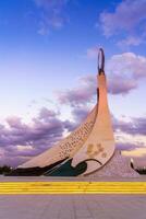 Uzbekistan, Tashkent - October 4, 2023 Monument of Independence in the form of a stele with a Humo bird on a twilight with cliody sky in the New Uzbekistan park. photo